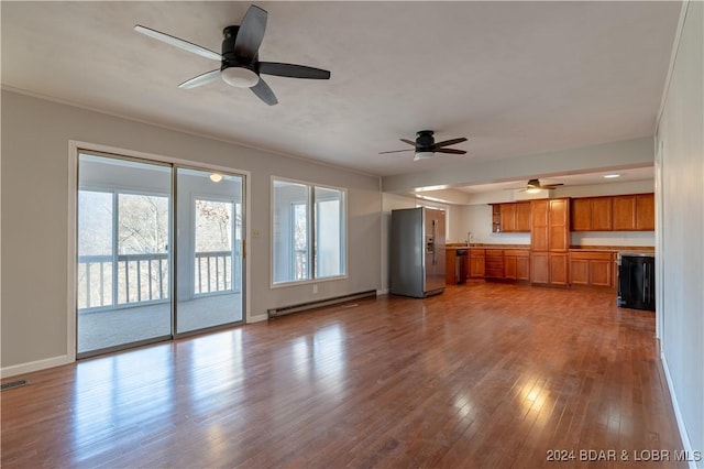 unfurnished living room featuring ornamental molding, baseboard heating, ceiling fan, sink, and wood-type flooring