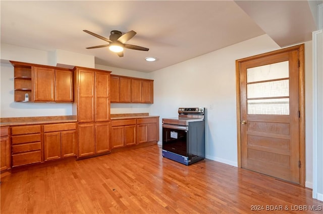 kitchen featuring stainless steel electric range oven, light hardwood / wood-style flooring, and ceiling fan