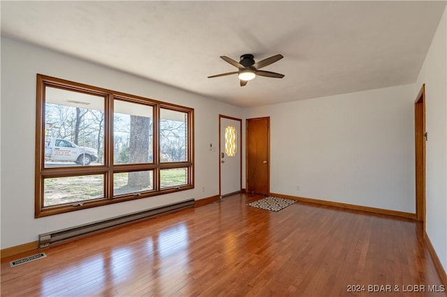 unfurnished room featuring light hardwood / wood-style floors, baseboard heating, and ceiling fan