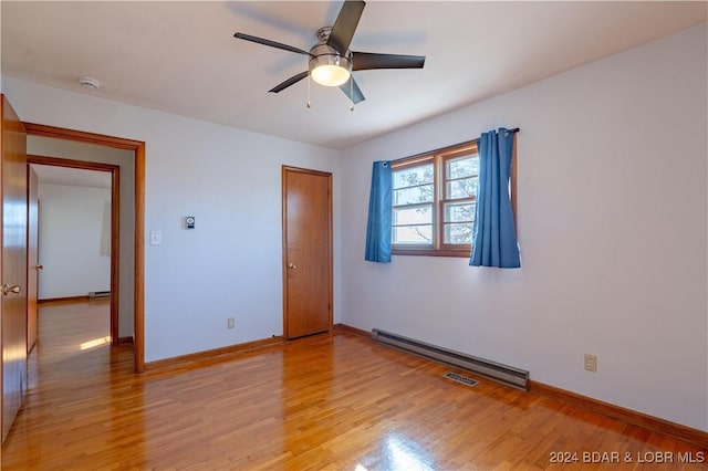 unfurnished bedroom with light hardwood / wood-style floors, a baseboard radiator, and ceiling fan