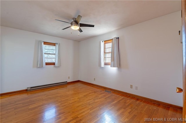 spare room with light hardwood / wood-style floors, baseboard heating, and ceiling fan