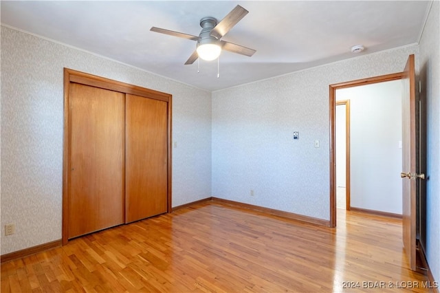 unfurnished bedroom with ceiling fan, a closet, and light wood-type flooring