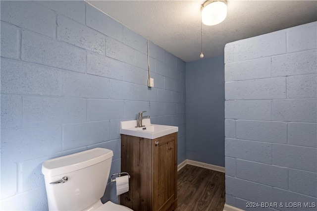 bathroom featuring toilet, vanity, a textured ceiling, and hardwood / wood-style flooring