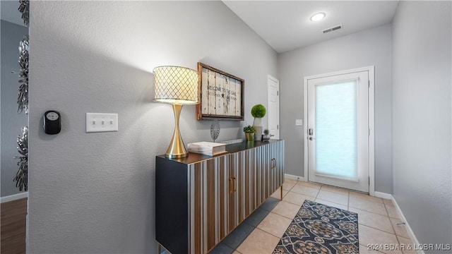 doorway with plenty of natural light and light tile patterned floors