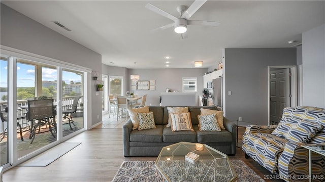 living room with light hardwood / wood-style flooring and ceiling fan