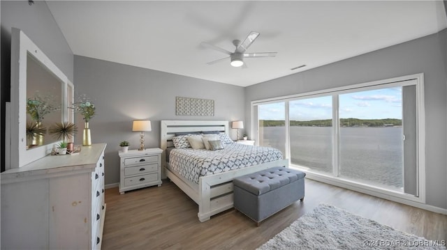 bedroom with access to outside, hardwood / wood-style flooring, and ceiling fan