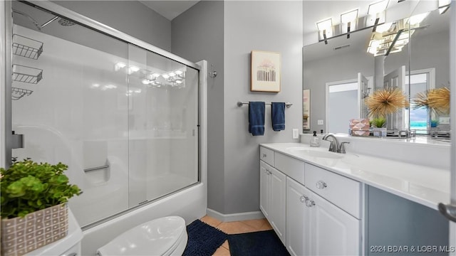 full bathroom featuring tile patterned flooring, vanity, combined bath / shower with glass door, and toilet