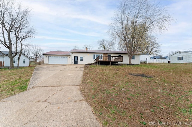 single story home with a garage, a wooden deck, and a front lawn