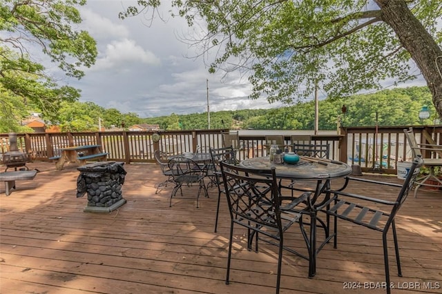 wooden terrace with a fire pit and outdoor dining space