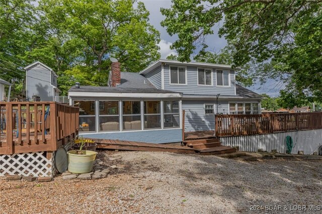 back of house featuring a sunroom and a deck