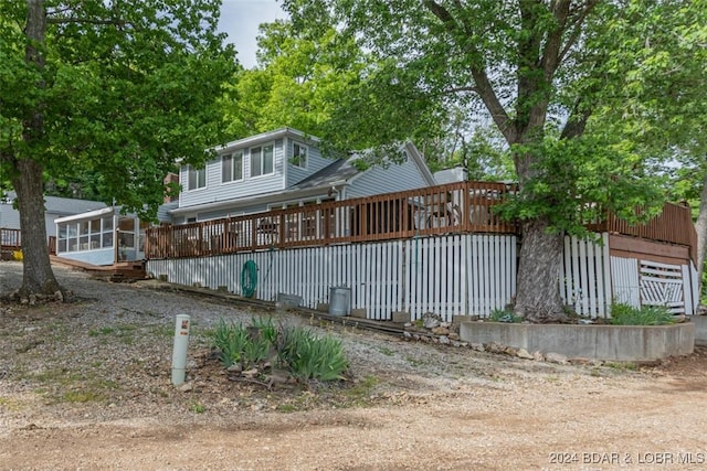 back of property featuring a deck and a sunroom