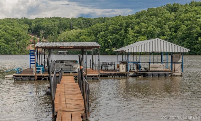 view of dock featuring a water view, boat lift, and a view of trees