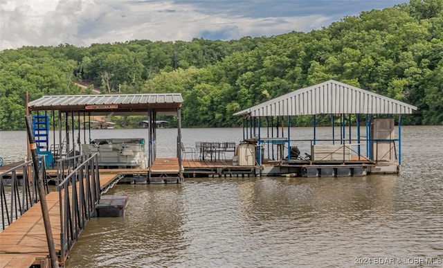 view of dock with a water view, a forest view, and boat lift