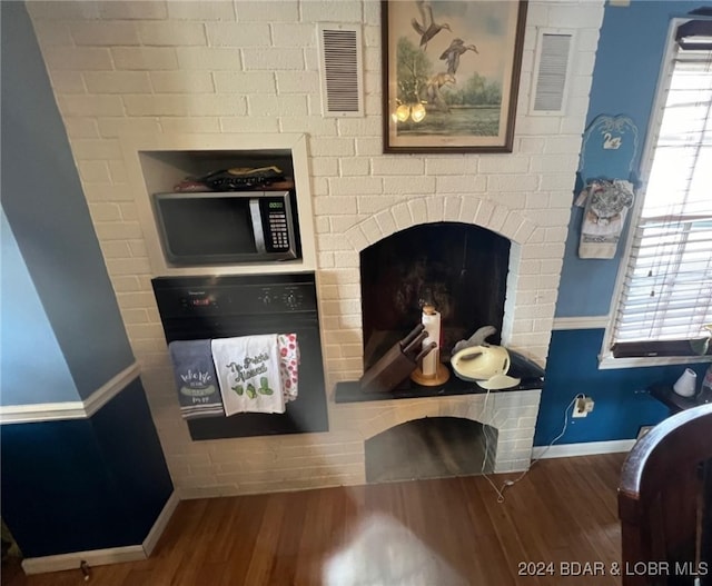 details with baseboards, visible vents, stainless steel microwave, wood finished floors, and oven