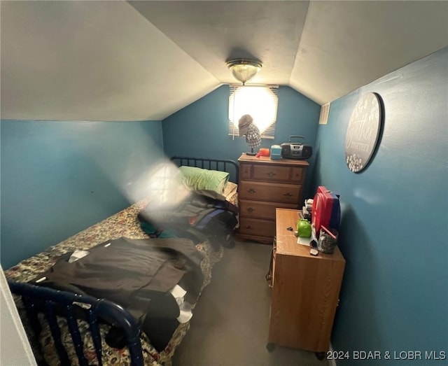 bedroom featuring lofted ceiling and carpet