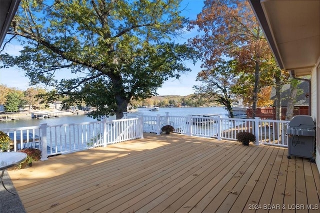 wooden deck with a grill and a water view