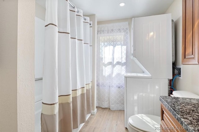 bathroom with wood-type flooring, vanity, toilet, and a shower with curtain