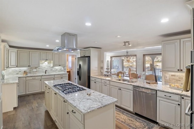 kitchen featuring island exhaust hood, stainless steel appliances, sink, wood-type flooring, and a kitchen island