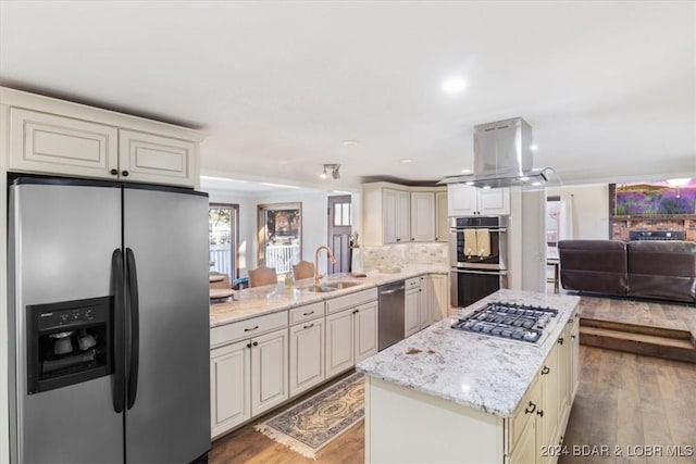 kitchen featuring kitchen peninsula, island range hood, hardwood / wood-style floors, and stainless steel appliances