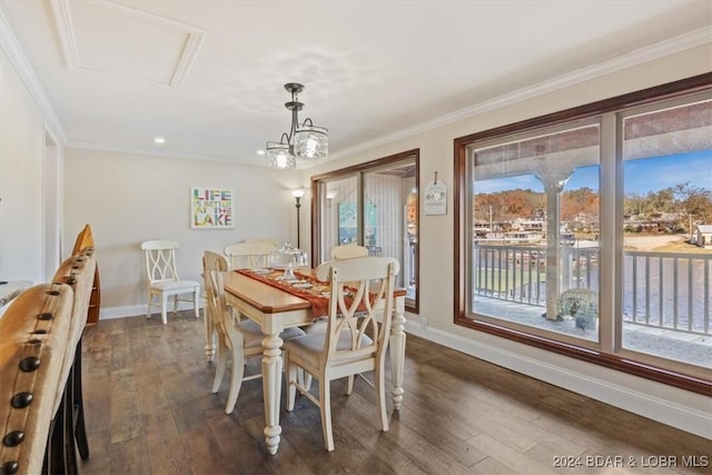 dining space featuring dark hardwood / wood-style flooring, crown molding, and a notable chandelier