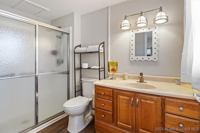 bathroom with toilet, vanity, an enclosed shower, and hardwood / wood-style flooring