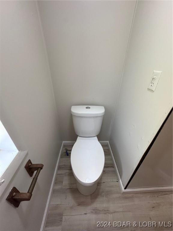 bathroom with wood-type flooring and toilet