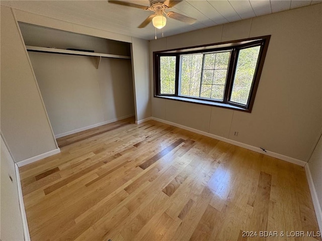 unfurnished bedroom with ceiling fan, a closet, and light hardwood / wood-style flooring