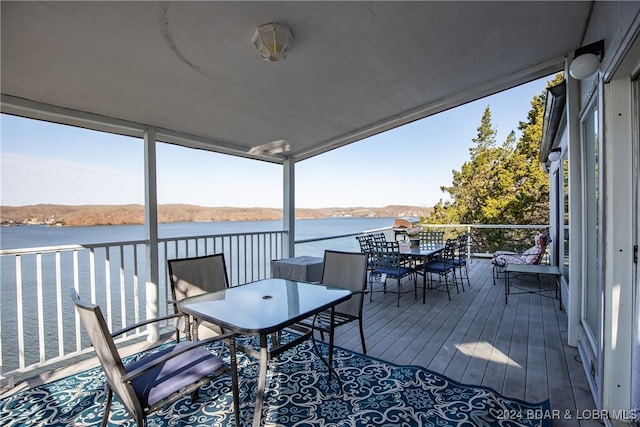 wooden deck featuring outdoor dining area and a water view