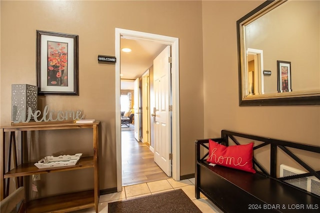 hallway featuring light tile patterned flooring and baseboards
