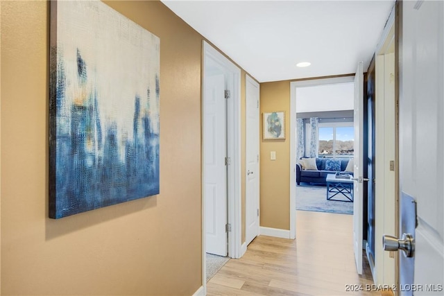 corridor featuring baseboards, wood finished floors, and recessed lighting