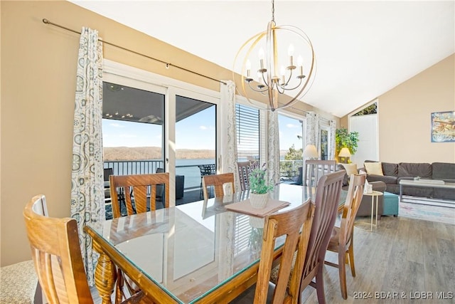 dining area featuring an inviting chandelier, wood finished floors, and vaulted ceiling