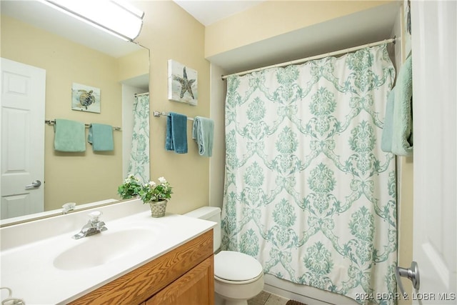 full bathroom featuring a shower with shower curtain, toilet, and vanity