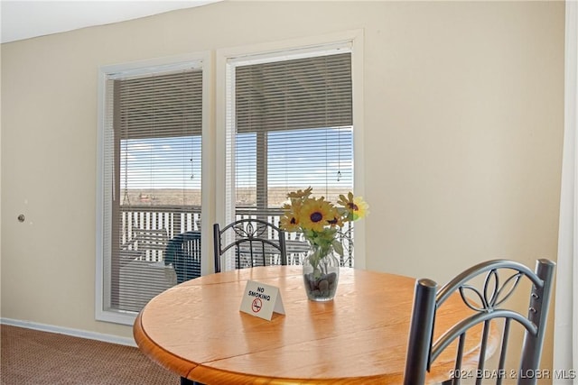 carpeted dining area featuring baseboards