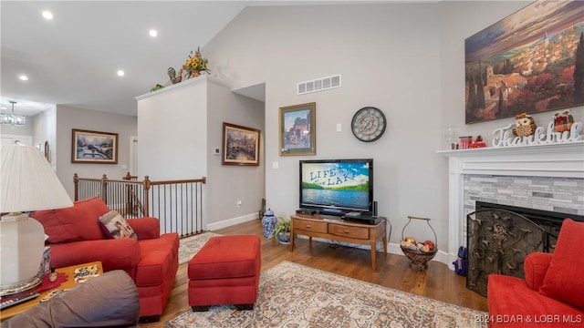 living room with hardwood / wood-style flooring, vaulted ceiling, and a notable chandelier