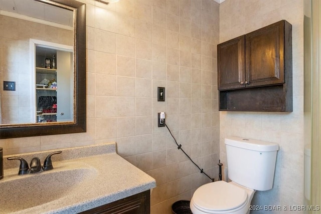 bathroom with vanity, ornamental molding, tile walls, and toilet