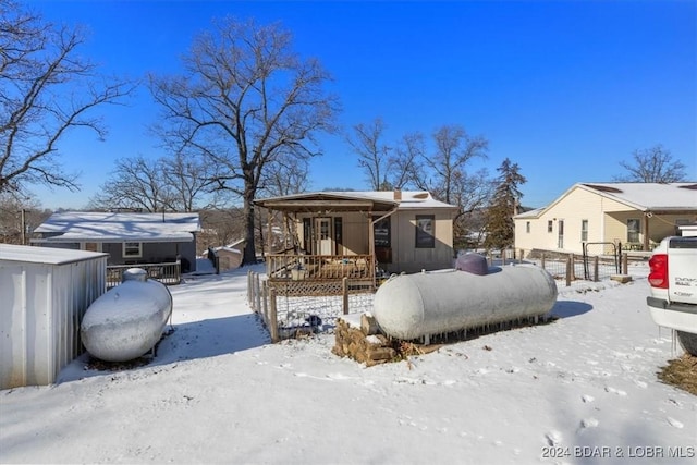 view of snow covered back of property