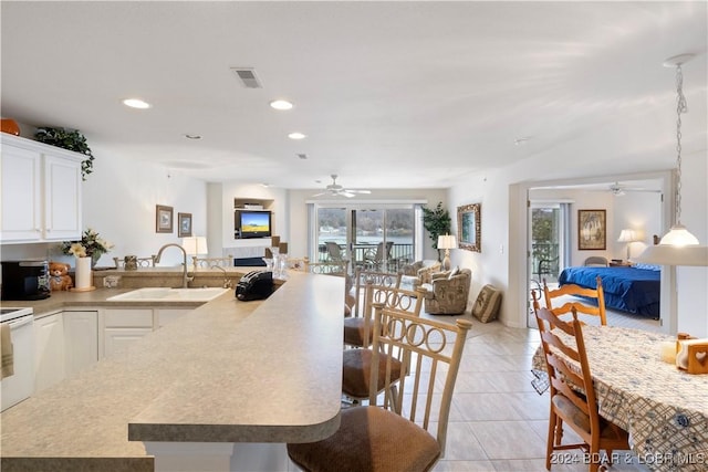 kitchen with a breakfast bar area, white cabinets, and a healthy amount of sunlight