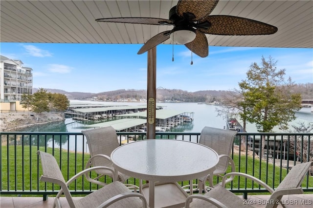 balcony with ceiling fan and a water view