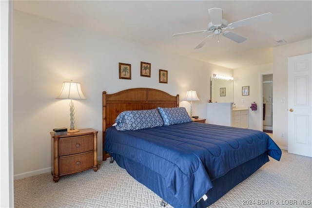 bedroom with light carpet, ensuite bath, and ceiling fan