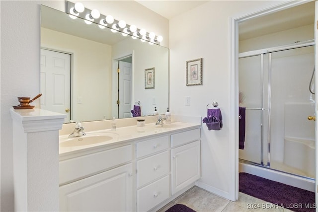 bathroom with tile patterned flooring, vanity, and walk in shower