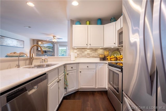 kitchen with sink, dark hardwood / wood-style floors, backsplash, white cabinets, and appliances with stainless steel finishes