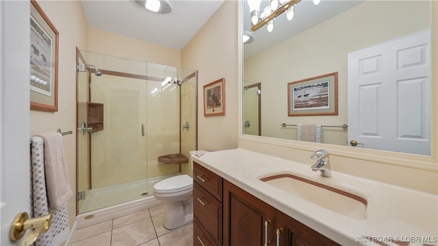 bathroom with toilet, vanity, tile patterned floors, and a shower with shower door