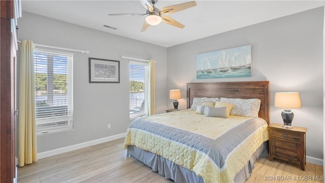 bedroom with ceiling fan, light wood-type flooring, and multiple windows