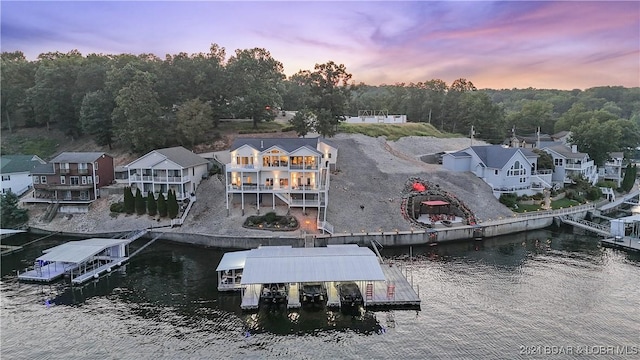 aerial view at dusk featuring a water view