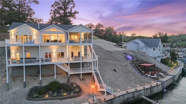 back house at dusk with a balcony