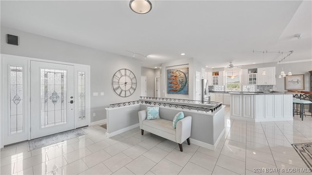 tiled entryway featuring rail lighting