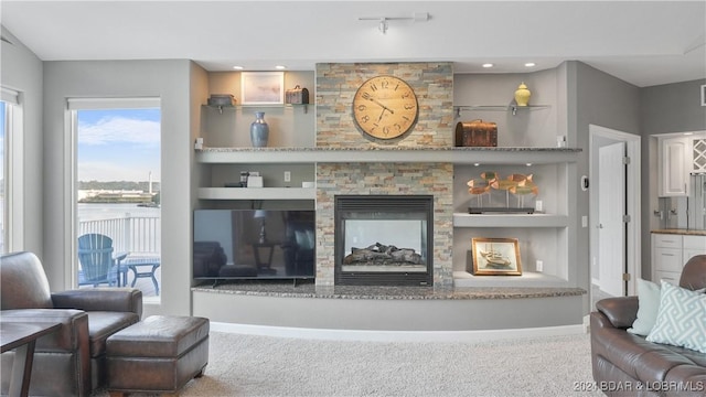 living room with a multi sided fireplace and built in features