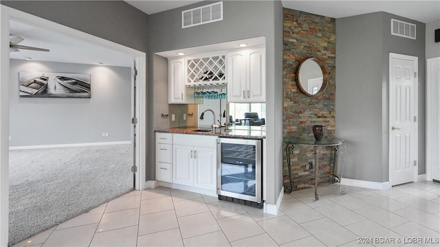 bar with light tile patterned floors, white cabinetry, wine cooler, and sink