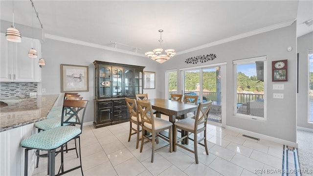 dining space with light tile patterned floors, crown molding, and an inviting chandelier