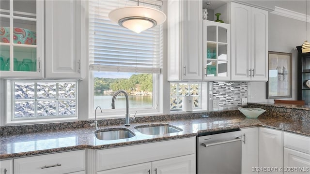 kitchen featuring dishwasher, backsplash, dark stone counters, sink, and white cabinetry